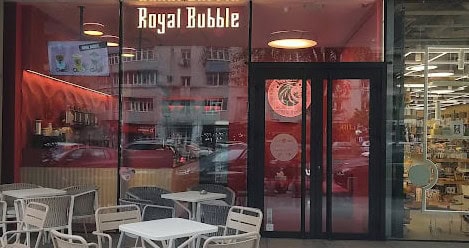 Royal Bubble storefront in Romania with its illuminated sign and red interior.
