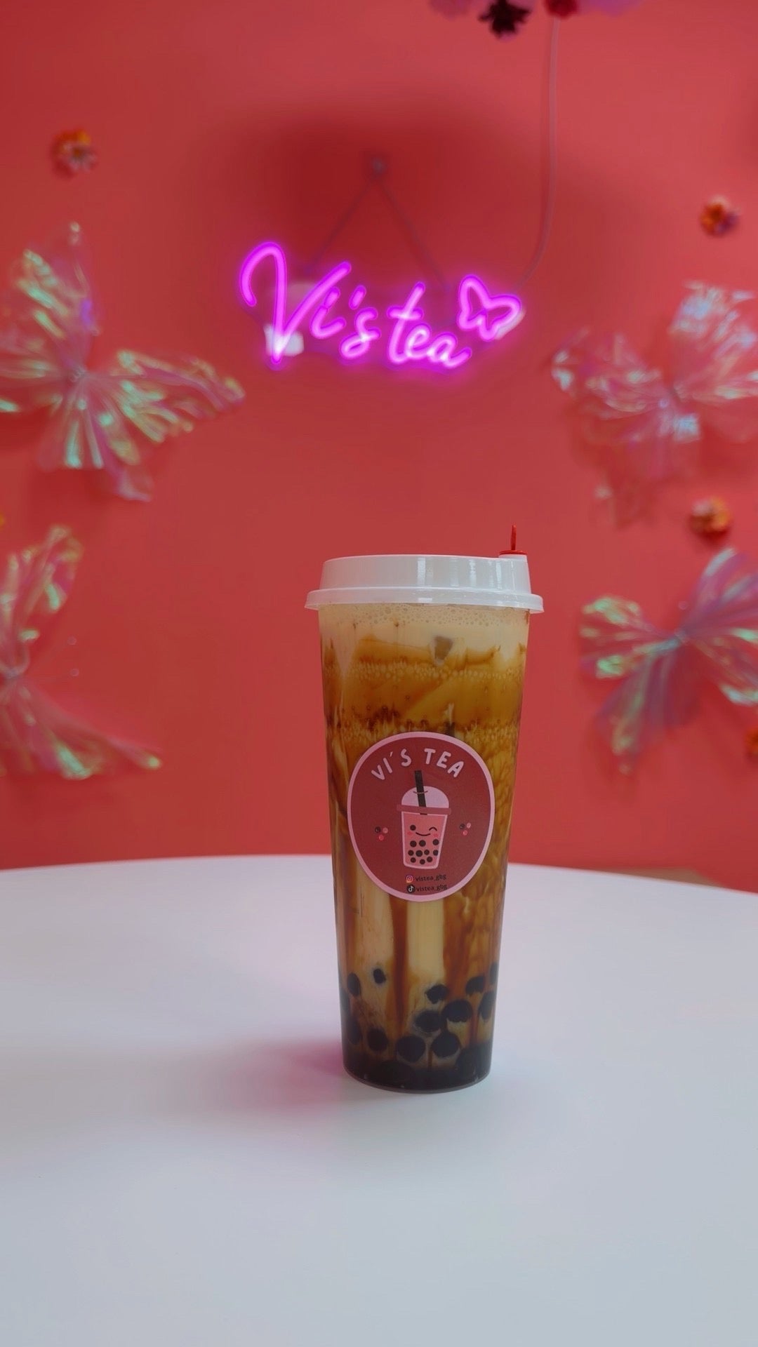 Vi’s Tea bubble tea in front of the café’s neon sign in Gothenburg.